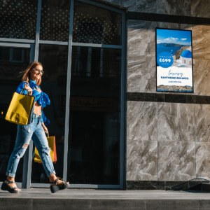 Woman walking past digital display on a wall