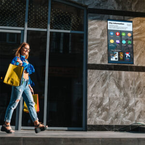 Woman walking past digital display on a wall